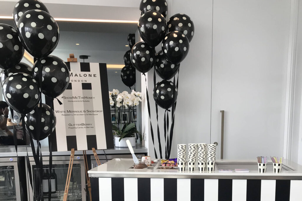 Tisch mit schwarzen und weißen Ballons darauf, perfekt für ein Catering-Event in Hamburg mit Eisrollen