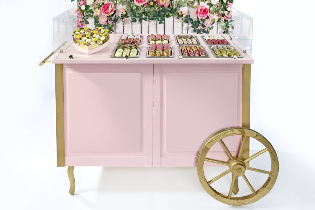 rosa Wagen mit einem Haufen Blumen darauf
